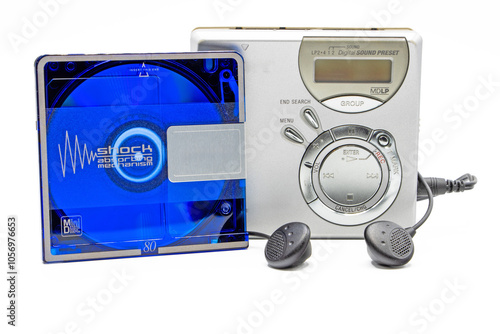 close-up of a minidisc player and recorder with headphones next to a minidisc record isolated on white background