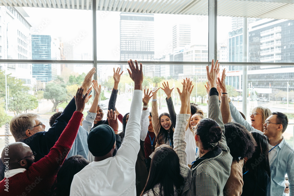 Fototapeta premium Happy work colleagues showcasing unity with raised hands
