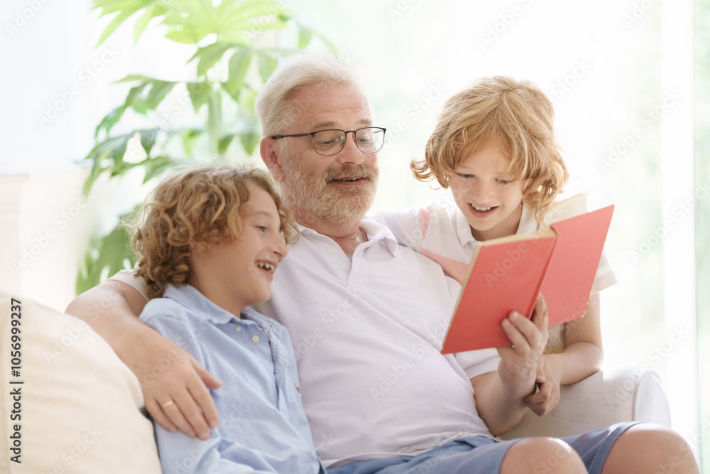 Grandfather and kids read book at home. Grandfather and kids read book at home.