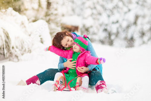 Child playing with snow in winter. Kids outdoors.