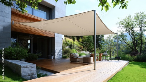 A modern outdoor space featuring a sleek shade canopy over a wooden deck, surrounded by lush greenery and a stylish seating area. photo