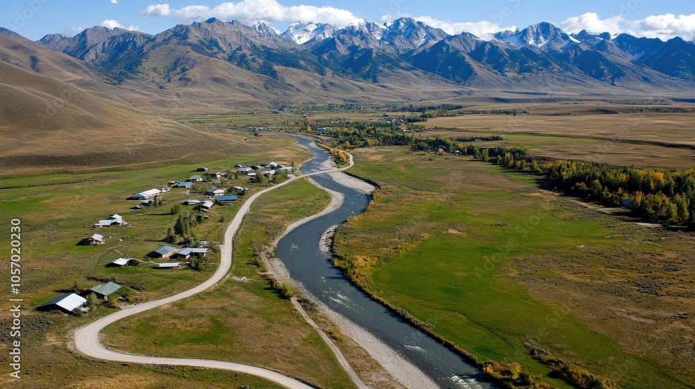 Fototapeta premium Aerial View of Winding River Through Mountain Valley in Autumn