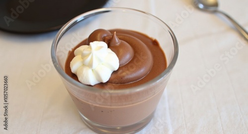 A delicate chocolate mousse with whipped cream, served in a glass cup