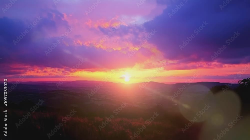 A vibrant sunset over hills, with clouds in shades of pink, purple, and orange. A vibrant sunset over hills, with clouds in shades of pink, purple, and orange.