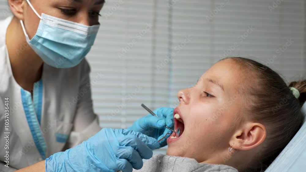 Dentist checking little girl teeth, close-up. Orthodontist examining child teeth in dentist office Dentist checking little girl teeth, close-up. Orthodontist examining child teeth in dentist office