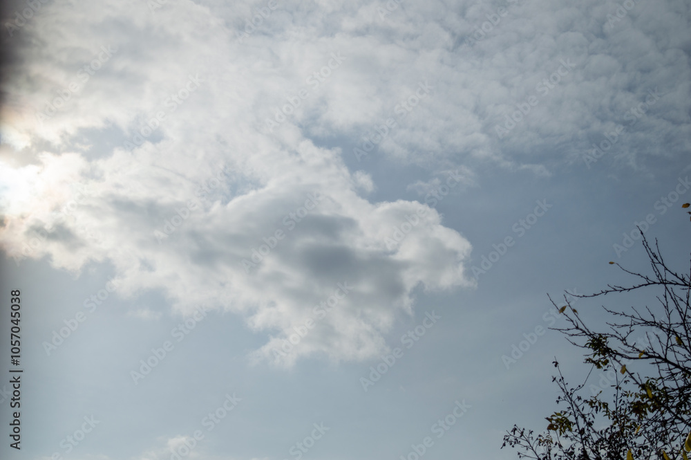 The photo captures a beautiful sky with fluffy white clouds against a clear blue background. The sun is shining brightly, casting a warm glow on the clouds. The photo captures a beautiful sky with fluffy white clouds against a clear blue background. The sun is shining brightly, casting a warm glow on the clouds.