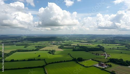 Lush green countryside under a cloudy sky with distant hills and a farm, aerial view isolated with white shades, png