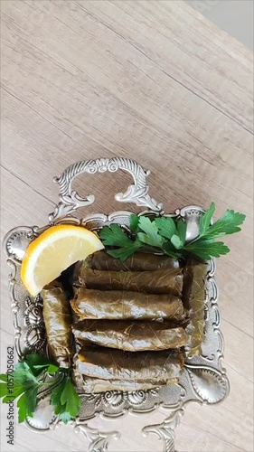 Traditional oriental Turkish dolma made of grape leaves stuffed with rice on a decorative plate