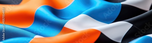 Colorful fabric wave with smooth texture and vibrant hues of blue, orange, black, and white. photo