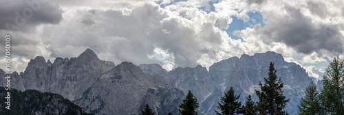 dettaglio sulle alte cime di una catena montuosa alpina in Friuli Venezia Giulia, nell'Italia nord orientale, di giorno, in estate, con un cielo coperto da grosse nubi photo