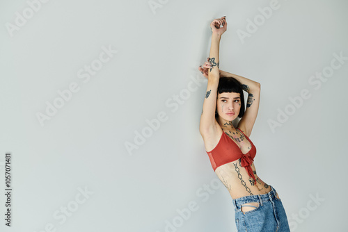A stylish tattooed woman strikes a pose in trendy attire.