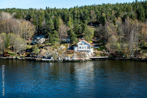 Small idyllic port in the Swedish archipelago outside of Stockholm with beautiful reflection lighted with sunspot at autumn evening. photo