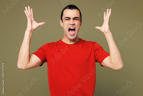 Young sad irritated concerned shocked mad middle eastern man he wear red t-shirt casual clothes scream shout spread hands isolated on plain pastel green background studio portrait. Lifestyle concept.