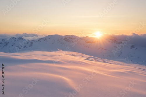 Sunrise over snow-covered mountains in serene winter landscape