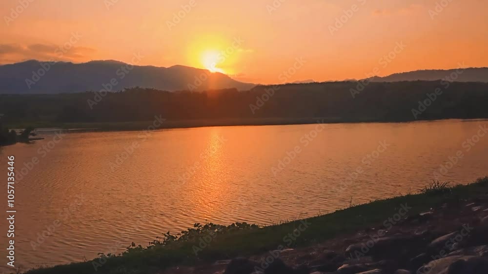 The sun sets behind the hill. The beauty of the sunset on the edge of the lake in the afternoon. The sun sets behind the hill. The beauty of the sunset on the edge of the lake in the afternoon.