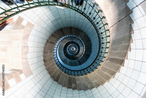 Mesmerizing spiral staircase winds its way upwards, creating a hypnotic pattern of light and shadow