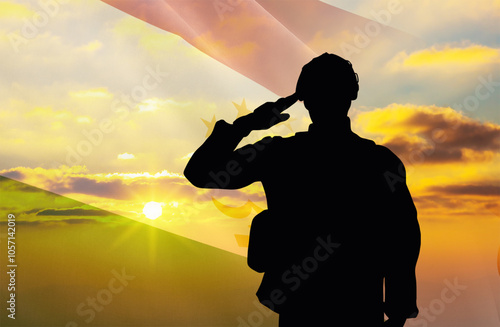 Silhouette of a soldier with a background of the Tajikistan flag and a sunset or sunrise. Concept of national holidays. Commemoration Day. photo