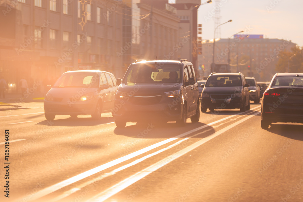 Autumn landscape and view of the road with cars. Orange evening sun and reflections on cars. Autumn landscape and view of the road with cars. Orange evening sun and reflections on cars.