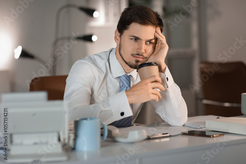 Stressed businessman drinki...