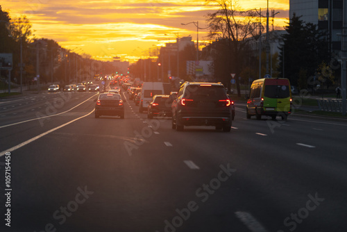 Autumn landscape and view of the road with cars. Orange evening sun and reflections on cars.