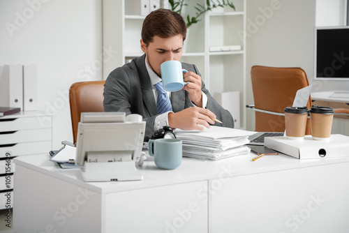 Stressed businessman drinki...
