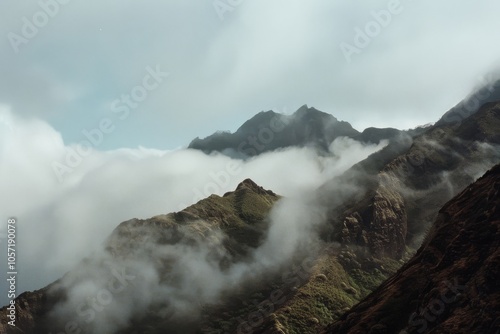 Mystical mountains shrouded in mist, rising majestically amidst swirling clouds, creating an awe-inspiring vista of nature’s grandeur and mystery.