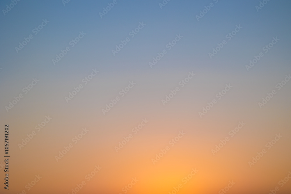 Fototapeta premium immagine sfuocata del cielo sereno al tramonto, con un gradiente che va dal colore azzurro all'arancione