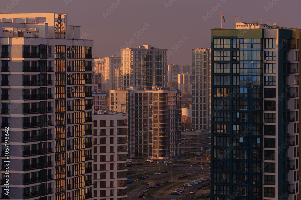 Evening view of the city. Sunset orange sky and beautiful cityscape, buildings and city streets, public place Evening view of the city. Sunset orange sky and beautiful cityscape, buildings and city streets, public place