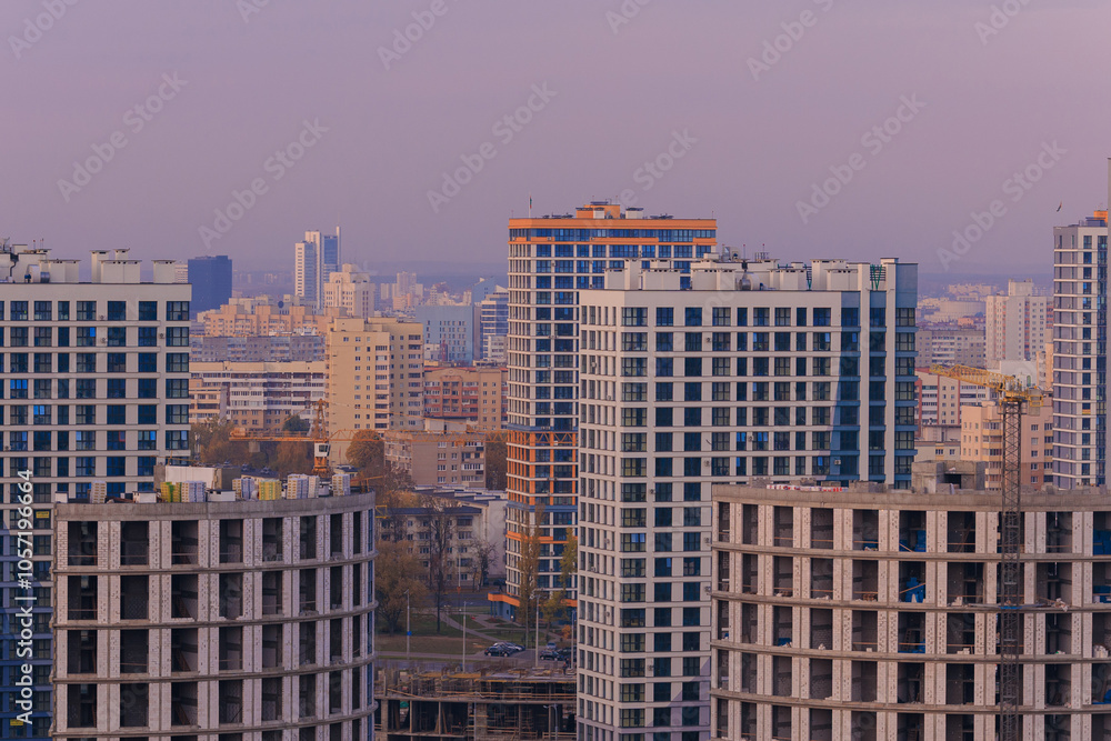 Evening view of the city. Sunset orange sky and beautiful cityscape, buildings and city streets, public place Evening view of the city. Sunset orange sky and beautiful cityscape, buildings and city streets, public place