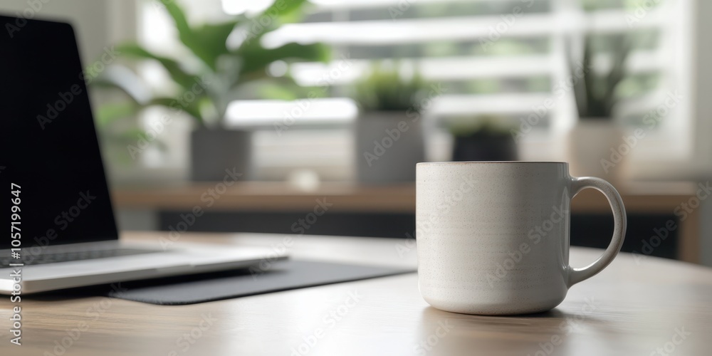 A cozy workspace featuring a white mug on a desk next to a laptop, surrounded by green plants and natural light. A cozy workspace featuring a white mug on a desk next to a laptop, surrounded by green plants and natural light.