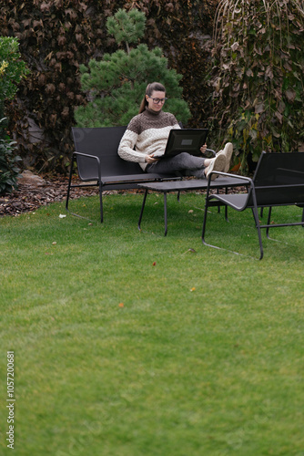 Woman working with a laptop in the backyard