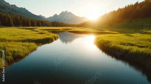 A picturesque river flows through vibrant green fields surrounded by trees, leading towards majestic mountains under the setting sun's warm glow in the distance.