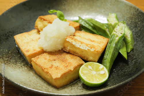 Fried tofu and fried okra served in Japanese style dishes.