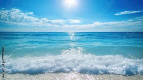 Clear blue ocean with gentle waves, sunlight creating a shimmering effect over the water