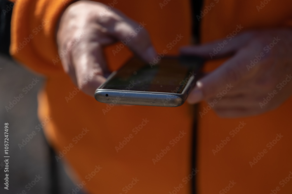 dettagli sulle mani di un uomo adulto caucasico mentre usa uno smartphone