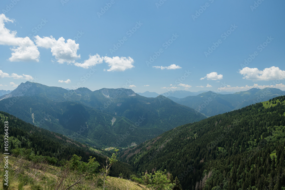 Obraz premium vista panoramica frontale in alta quota su di un ambiente naturale nelle Alpi Italiane a nord-est, con tante catene montuose che si estendono verso l'orizzonte, nella foschia, di mattina, in primavera