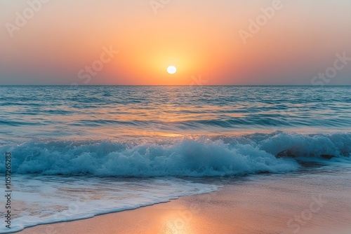 Picturesque sunset over the sea A dramatic view of a sunset with the sun setting over the ocean in warm orange tones as the waves gently crash onto the shore. photo