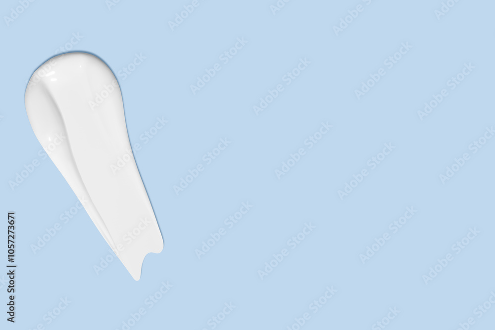 Smear of white cosmetic cream on a light blue background. Skincare product, smooth texture. Smear of white cosmetic cream on a light blue background. Skincare product, smooth texture.