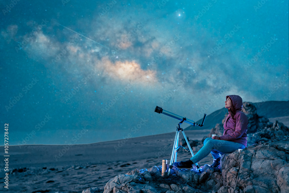 Fototapeta premium woman sitting in the desert alone contemplating the starry sky and the milky way in the background