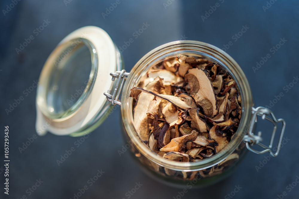 Open glass jar with dried mushrooms. Top view