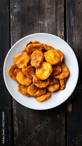 Plate of freshly fried plantains is sitting on a rustic wooden table, adding a touch of sweet and savory goodness to the scene