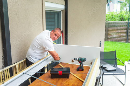 Handyman assembling furniture using cordless screwdriver at home