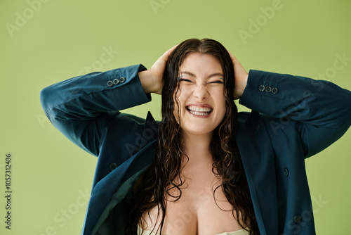 Photography A cheerful plus size woman with curly hair enjoys a fun pose while wearing a chic suit in a studio setting