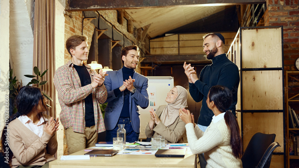 © master1305 - Colleagues from various cultural backgrounds applaud one another around conference table, showing appreciation and encouragement. Concept of dei in business, teamwork, corporate culture © master1305 - Colleagues from various cultural backgrounds applaud one another around conference table, showing appreciation and encouragement. Concept of dei in business, teamwork, corporate culture