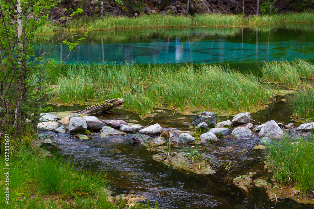 Summer landscape with Geyser Lake in the Altai Republic, Russia. The lake is also called Silver or Blue Lake. The water in the lake is turquoise Summer landscape with Geyser Lake in the Altai Republic, Russia. The lake is also called Silver or Blue Lake. The water in the lake is turquoise