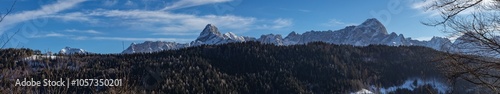 ampia composizione panoramica da immagini multiple su un bellissimo ambiente naturale di montagna freddo ed innevato, nell'Italia nord orientale, al tramonto, in inverno, sotto un cielo sereno