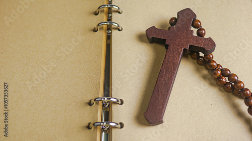 фотографія Dark red wooden cross leaning against an old open book symbolizing the spread of Jesus Christs love among Christians reflecting faith devotion and the importance of Christian teachings
