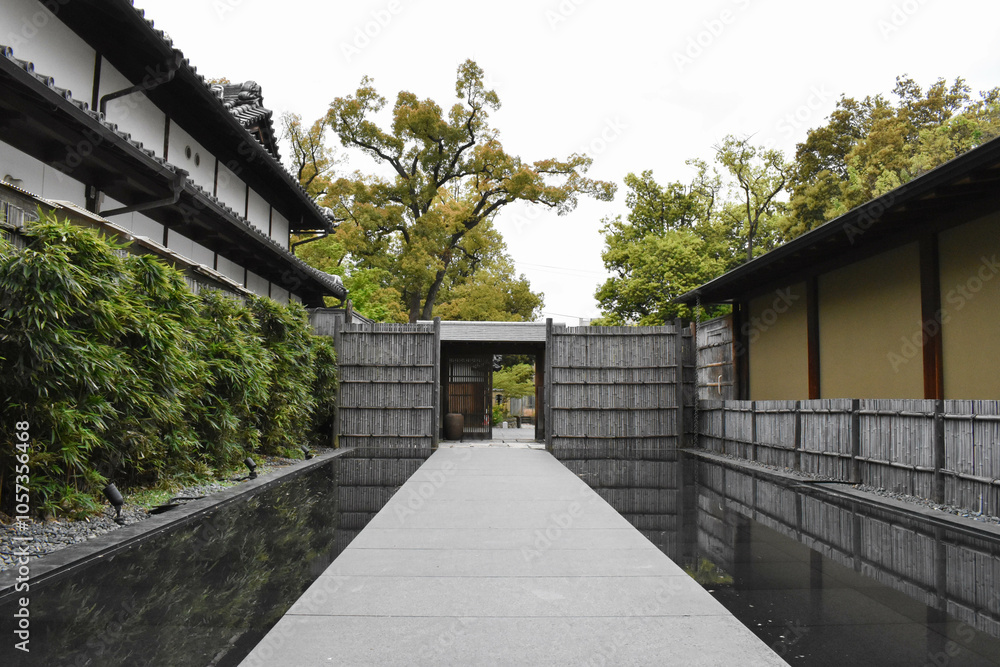Pathway by Water Leading to a Japanese Style Door in a Traditional Japanese Garden Pathway by Water Leading to a Japanese Style Door in a Traditional Japanese Garden