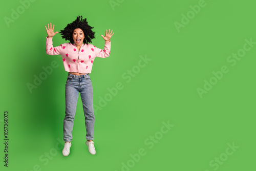 Full body photo of attractive young woman excited jump scream dressed strawberry print clothes isolated on green color background