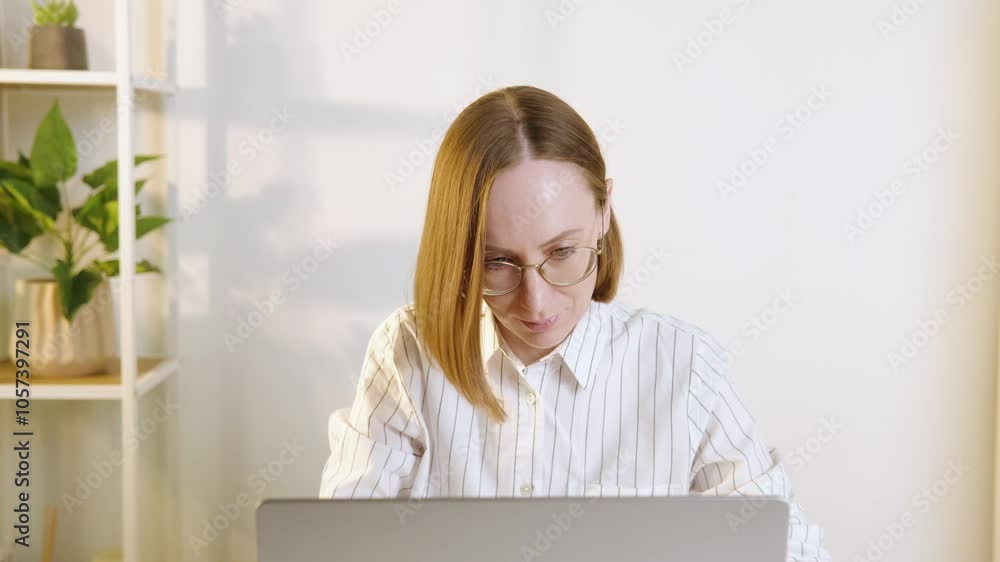 A woman working diligently at her laptop in a bright home office environment A woman working diligently at her laptop in a bright home office environment